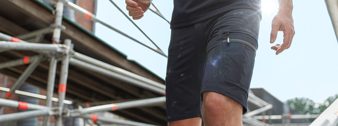 Man with work shorts on scaffold